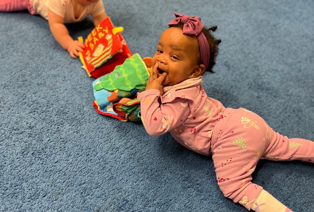 Infants playing with a toy.
