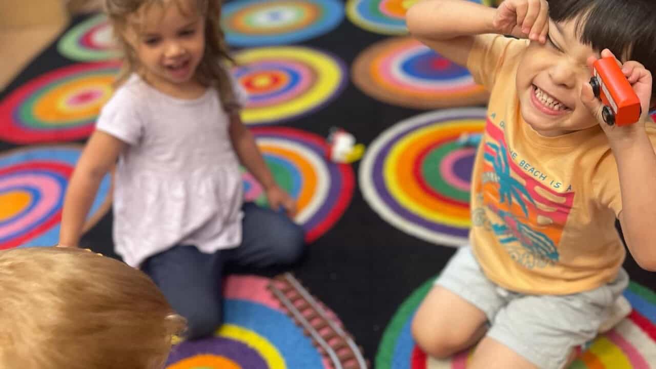 Little kids playing and making faces at the camera.